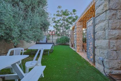 Spacious yard and a large dining area for a group at a villa in Netanya